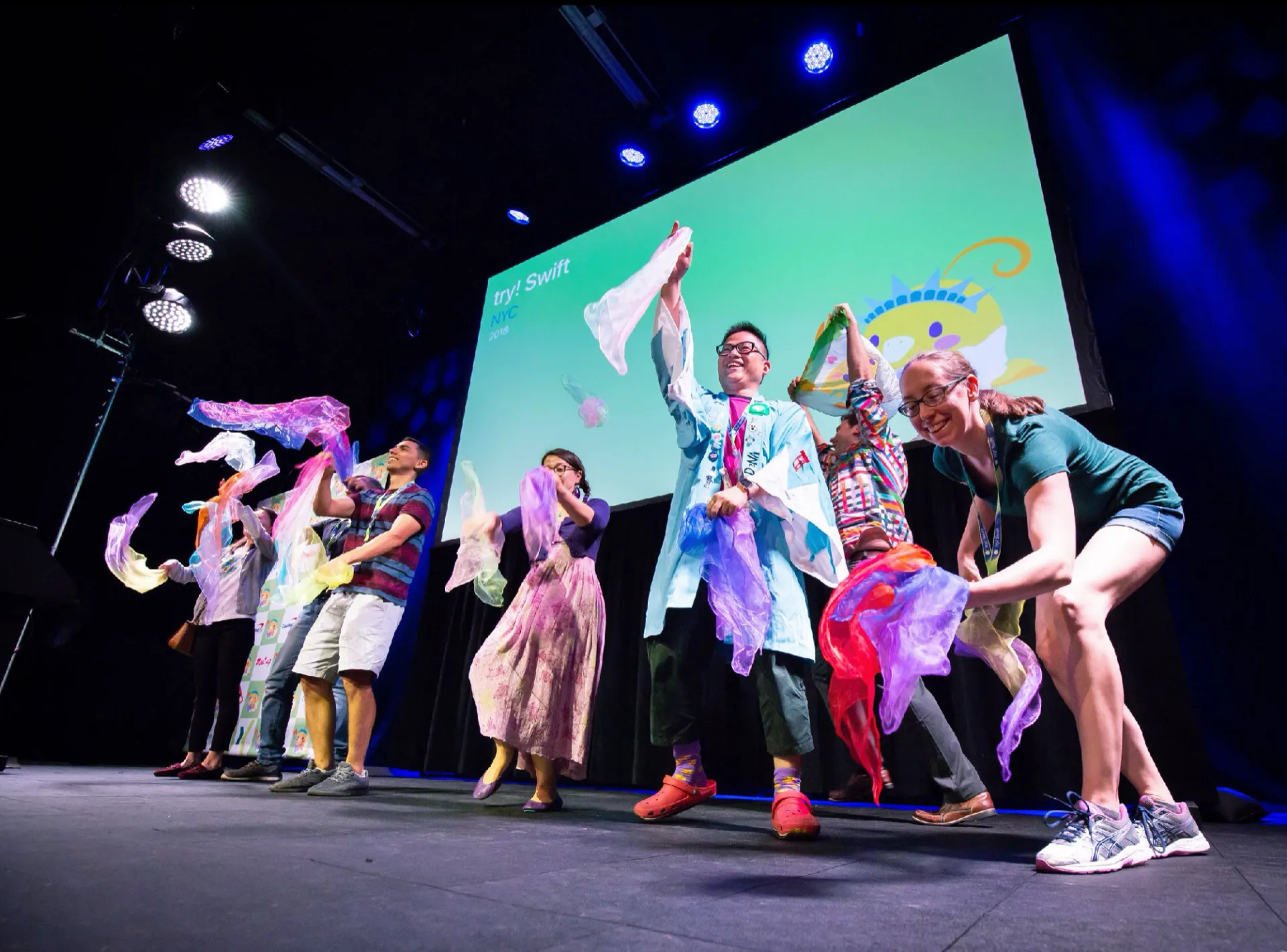 Attendees of Try!Swift iOS developer conference juggle together in front of 500 of their peers after learning how in a team workshop.